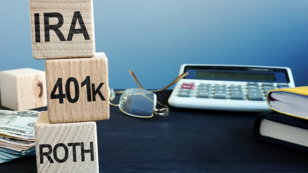 401(k) Retirement Planning - Wooden blocks stacked that say 'IRA' '401k' and 'ROTH'