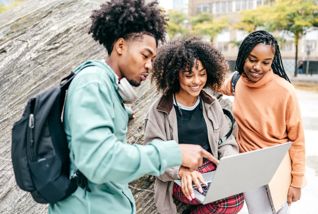 Young adults with backpacks and laptop looking at money tips for college students online