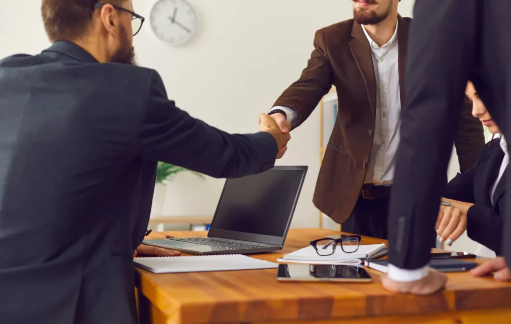 Financial advisor shaking hands with client over desk